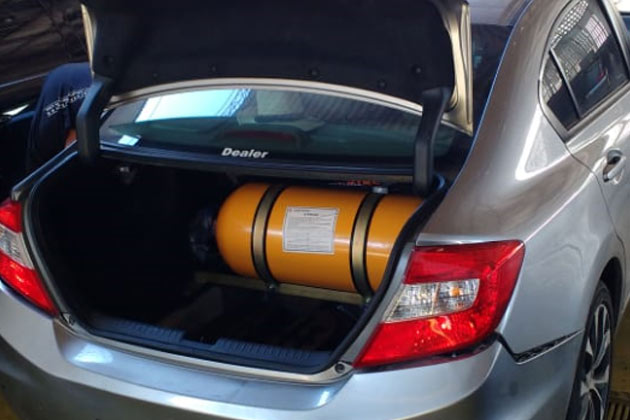 carro com mala aberta e cilindro de gnv amarelo e pequeno dentro da mala
